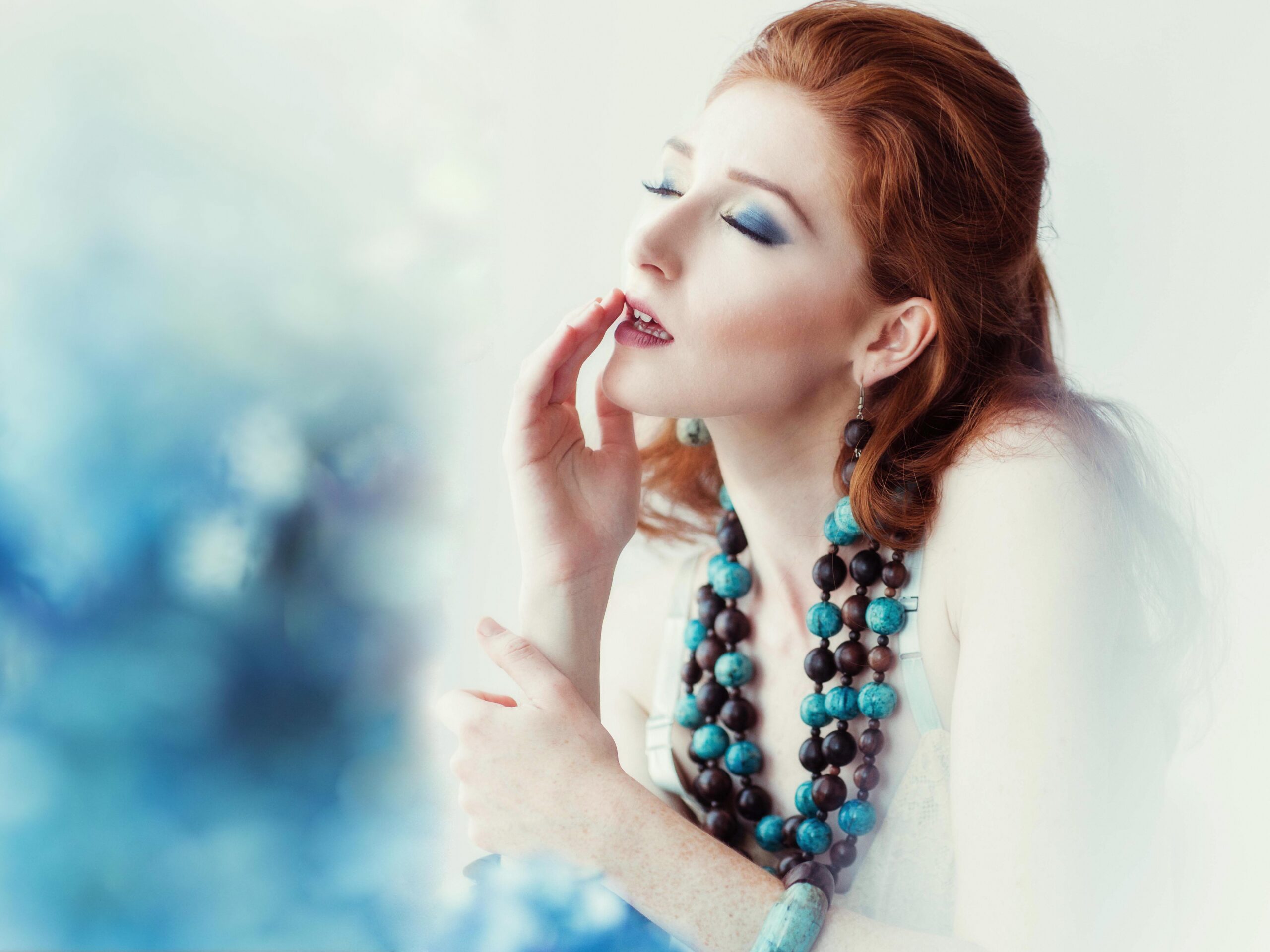 Red Head woman in large blue cultural necklace
