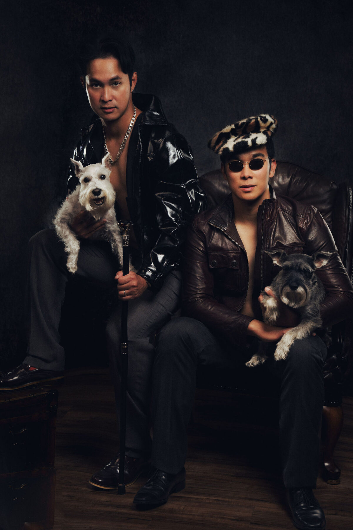 two men in a vanity fair set up carrying tiny dogs