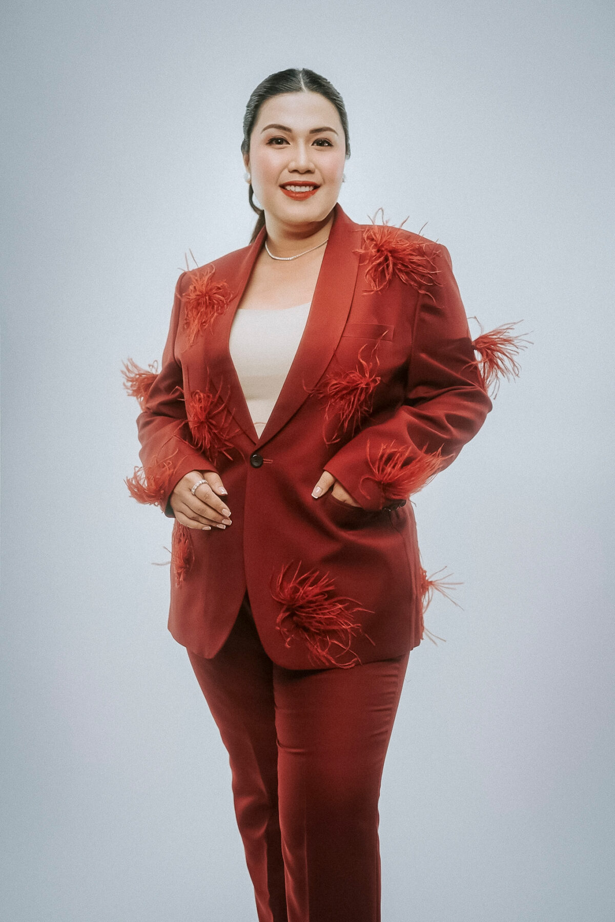 woman in red blazer with feathers