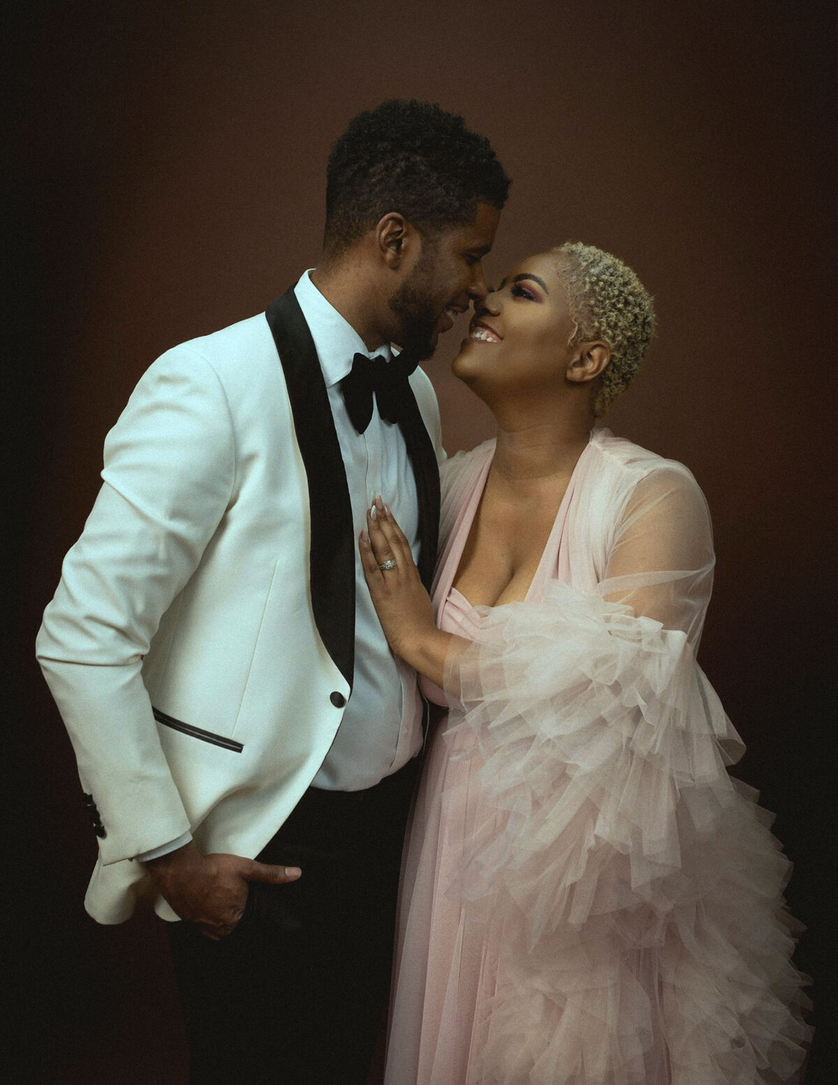 a couple wearing pink ruffled gowns and man wearing white tuxedo 