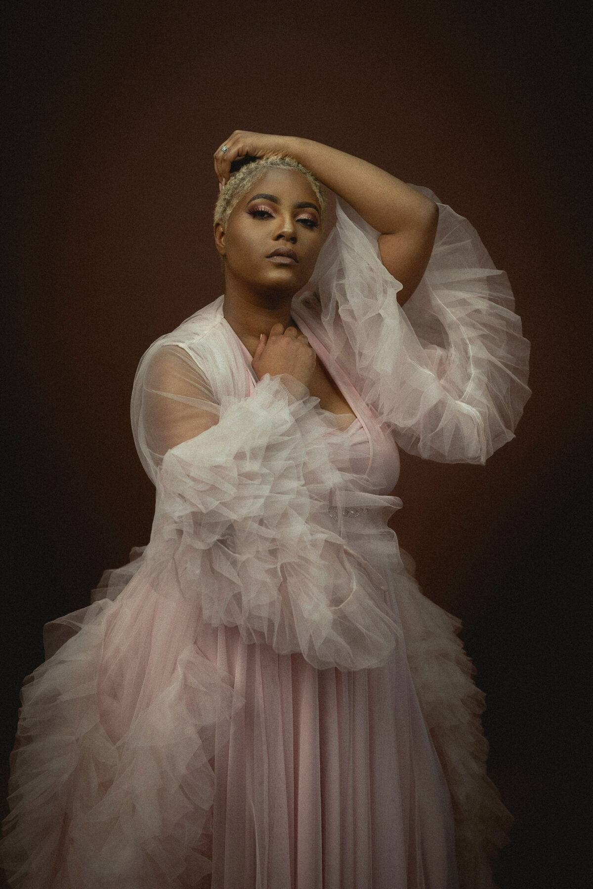 a dark skinned lady wearing a pink gown for vanity fair portraits